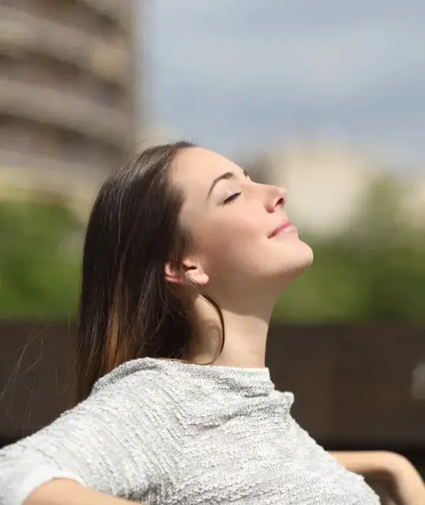 woman breathing deep fresh air to lower cortisol levels