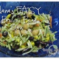 A blue bowl filled with Broccoli Slaw Salad—chickpeas, black beans, shredded carrots, and corn. Text over the image reads: Nanas EASY Broccoli Bean Slaw and happy green mama in the corner.