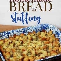 A blue speckled baking dish filled with homemade bread stuffing made of cubed, toasted bread sits on a wooden surface. The text above reads, homemade BREAD stuffing.